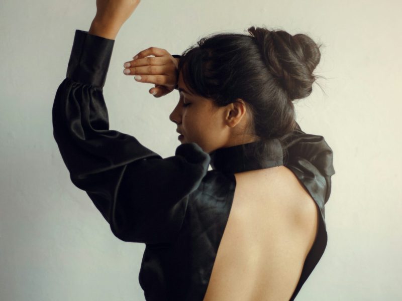 Mujer de perfil con vestido negro: inspiración de estilo y silueta