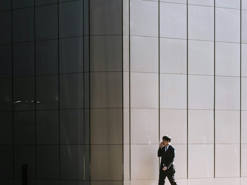 Ejecutivo caminando frente a edificio moderno: imagen profesional y coherencia de marca